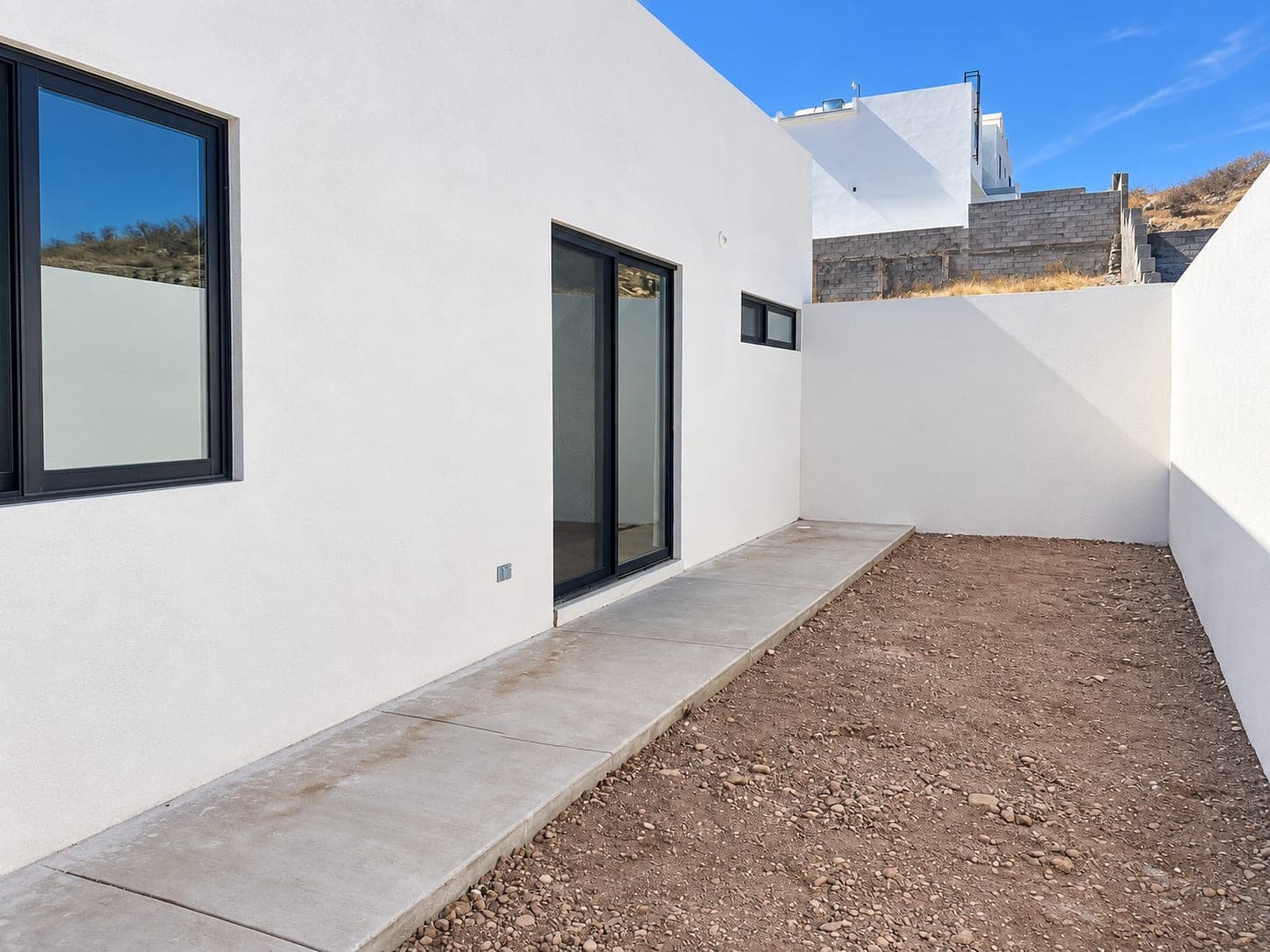 Patio trasero de Casa Aurora con andador de concreto