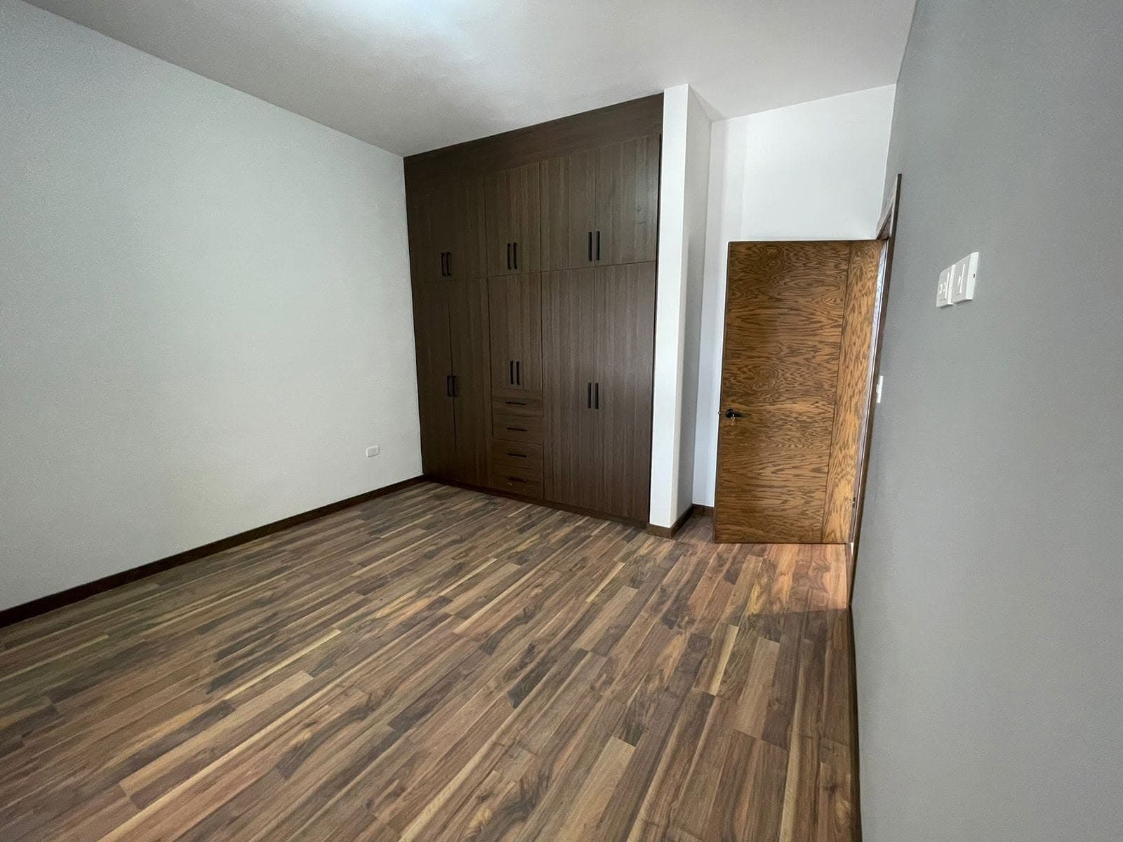 Recámara de Casa Aurora con clóset de madera de piso a techo